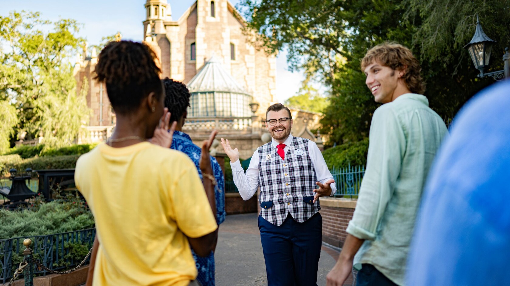 A VIP Tour Guide approaching the Haunted Mansion in Magic Kingdom park with Guests