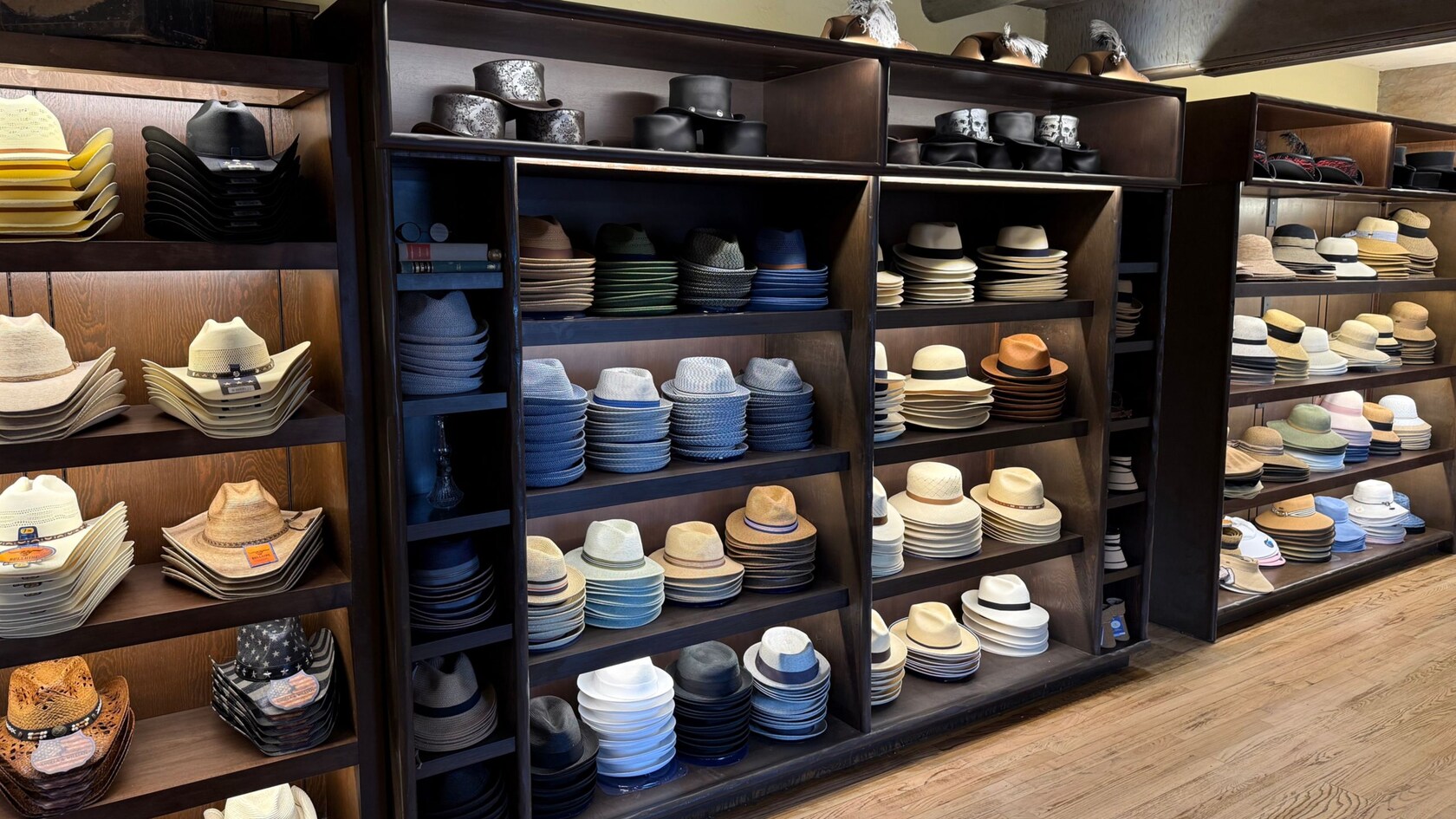 Wooden shelves displaying different kinds of hats inside of Prairie Outpost at Magic Kingdom park