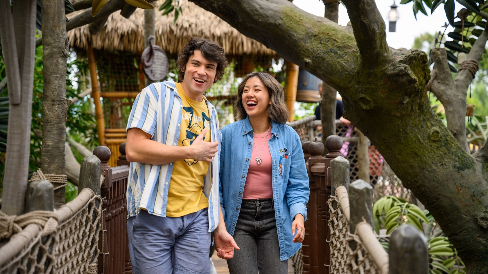 Two young adults walking across a bridge at Adventureland Treehouse inspired by Walt Disney's Swiss Family Robinson