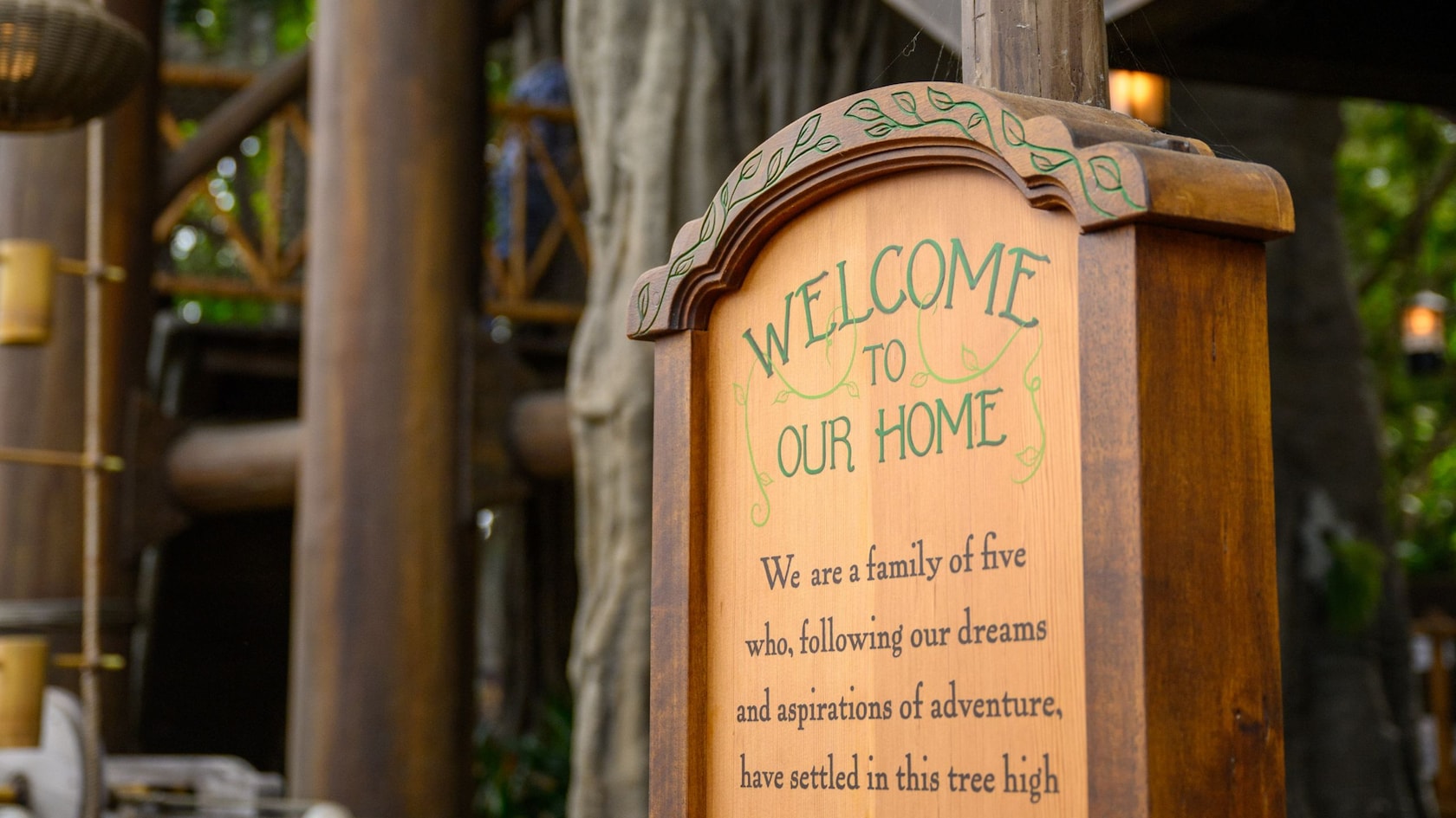 A welcome message on a wooden sign at the entrance to Adventureland Treehouse inspired by Walt Disney's Swiss Family Robinson