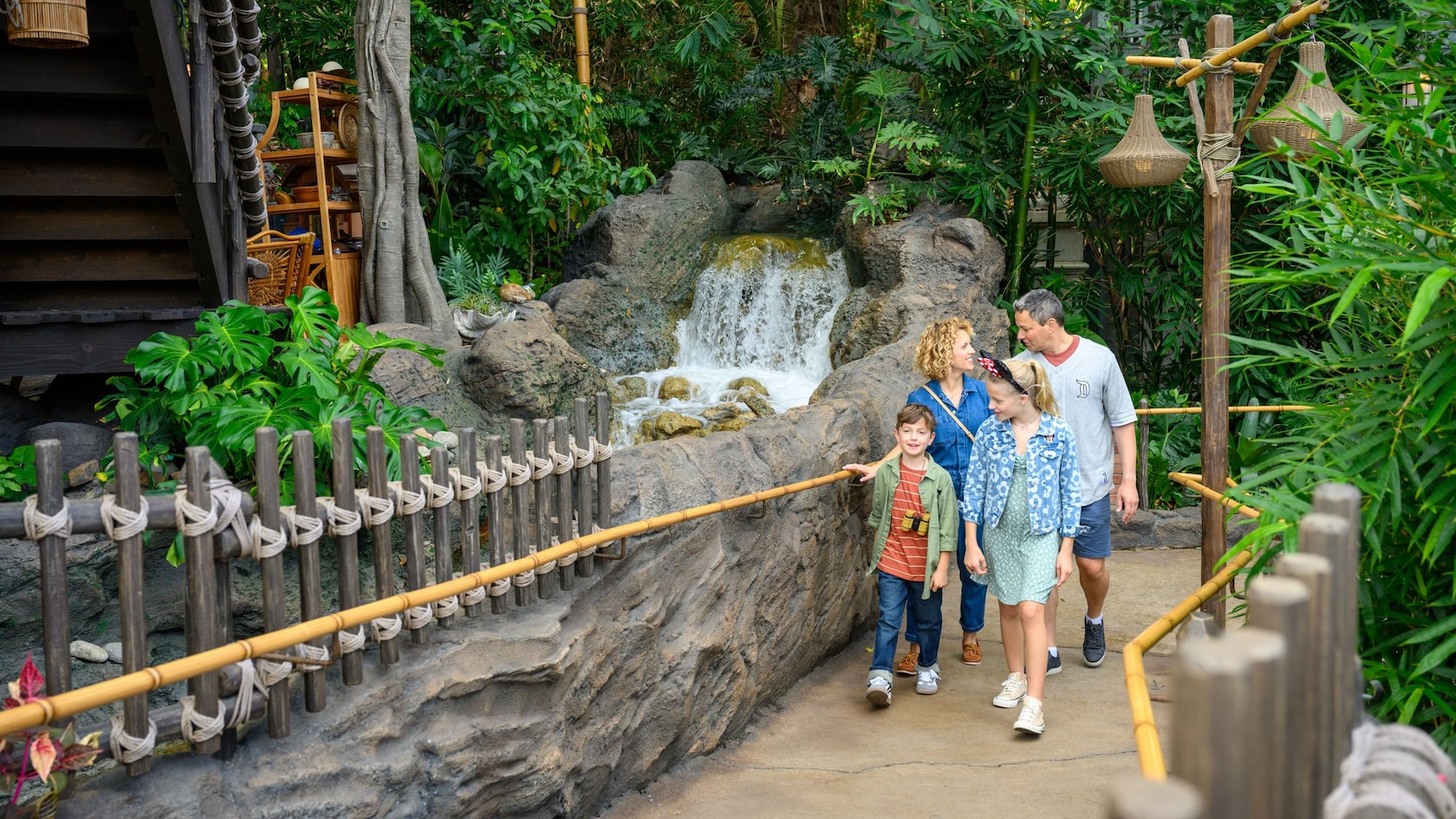 A family of four walking along a stream at Adventureland Treehouse inspired by Walt Disney's Swiss Family Robinson