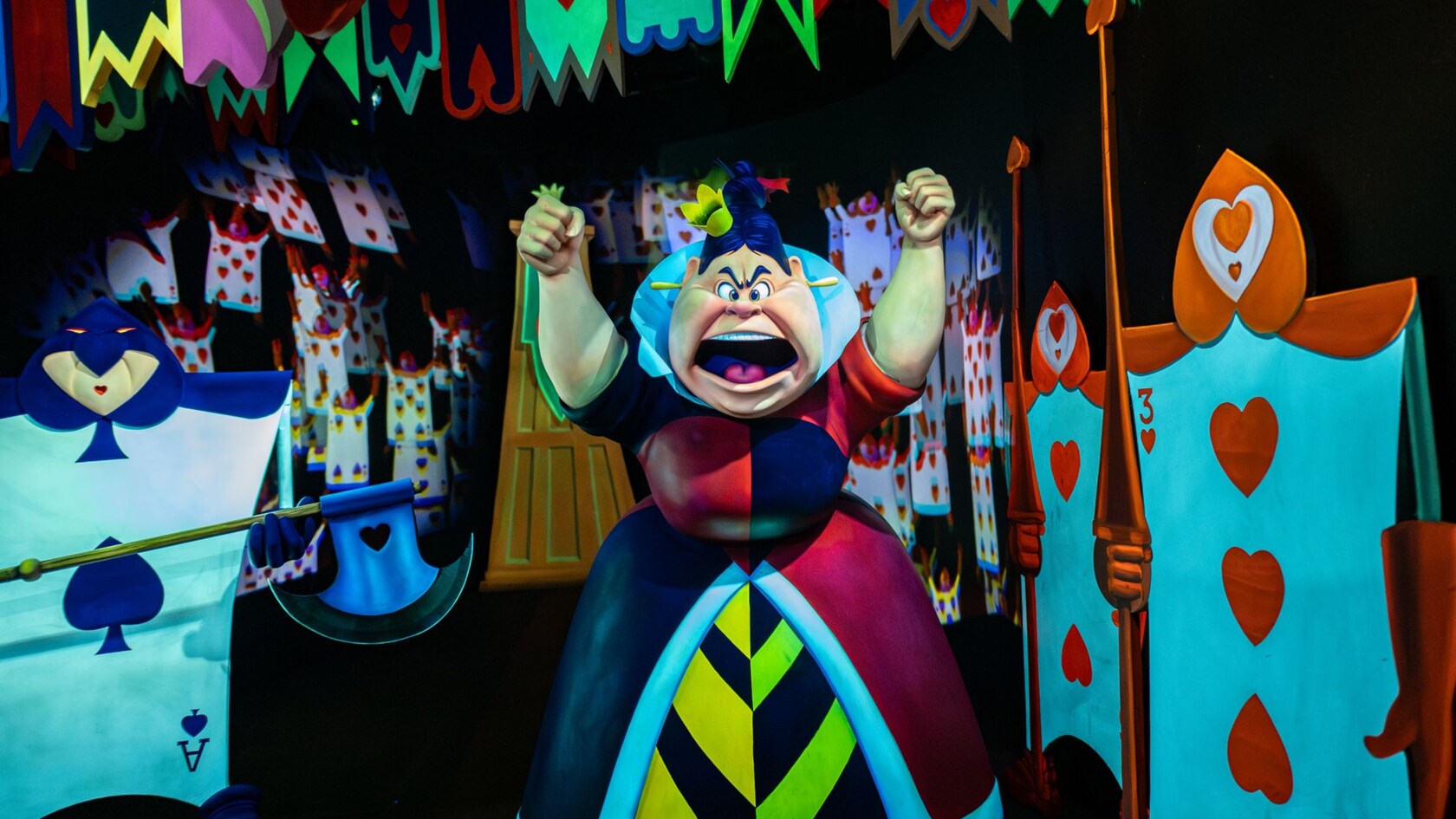 The Queen of Hearts yelling while surrounded by playing card soldiers at Alice in Wonderland