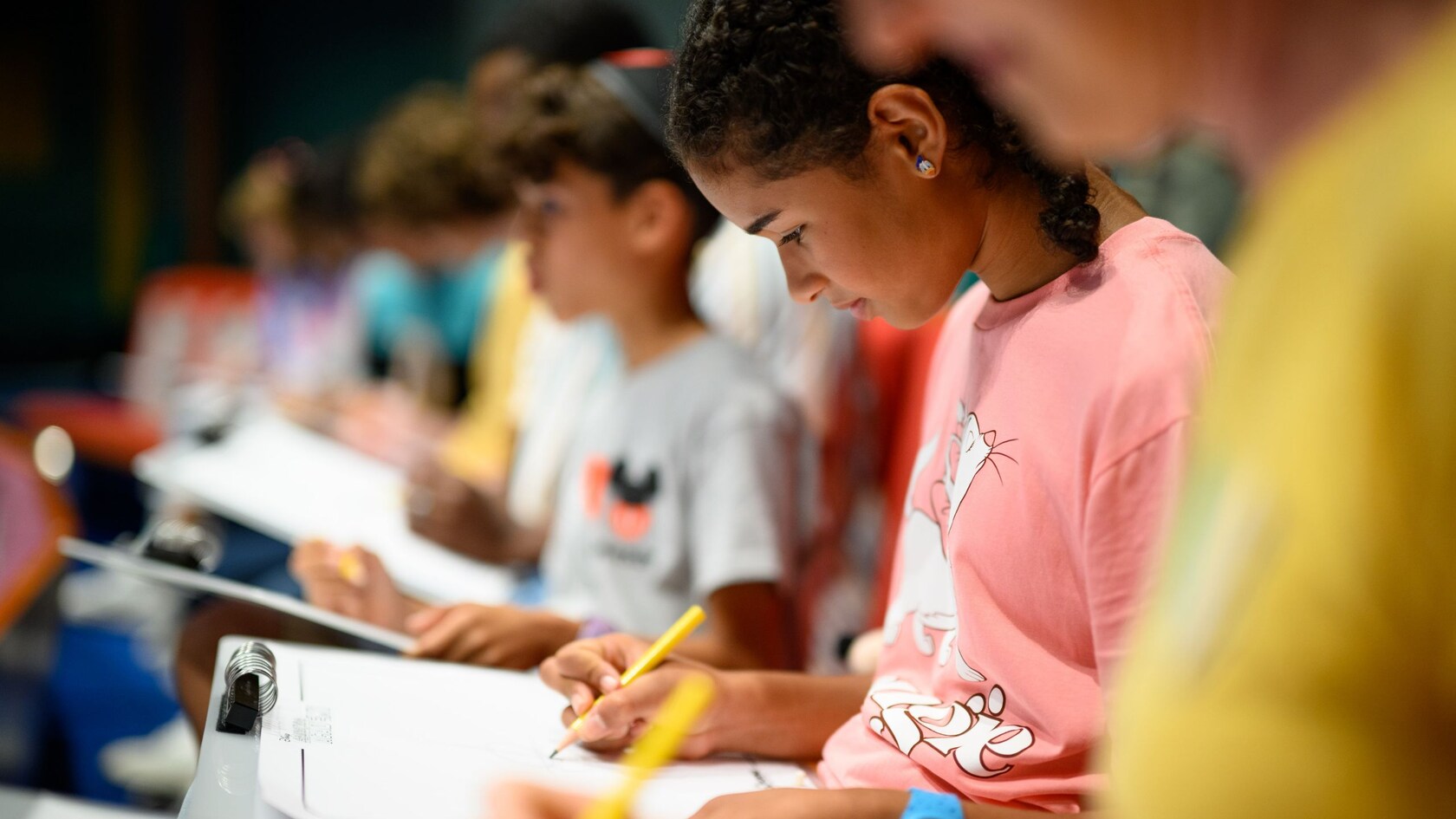 Guests focused on drawing during an illustration lesson at Animation Academy in Disney California Adventure Park
