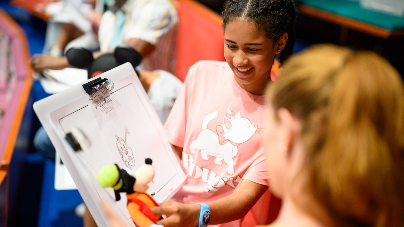 A young Guest showing a Goofy sketch to a Cast Member during an illustration lesson in Animation Academy at Disney California Adventure Park