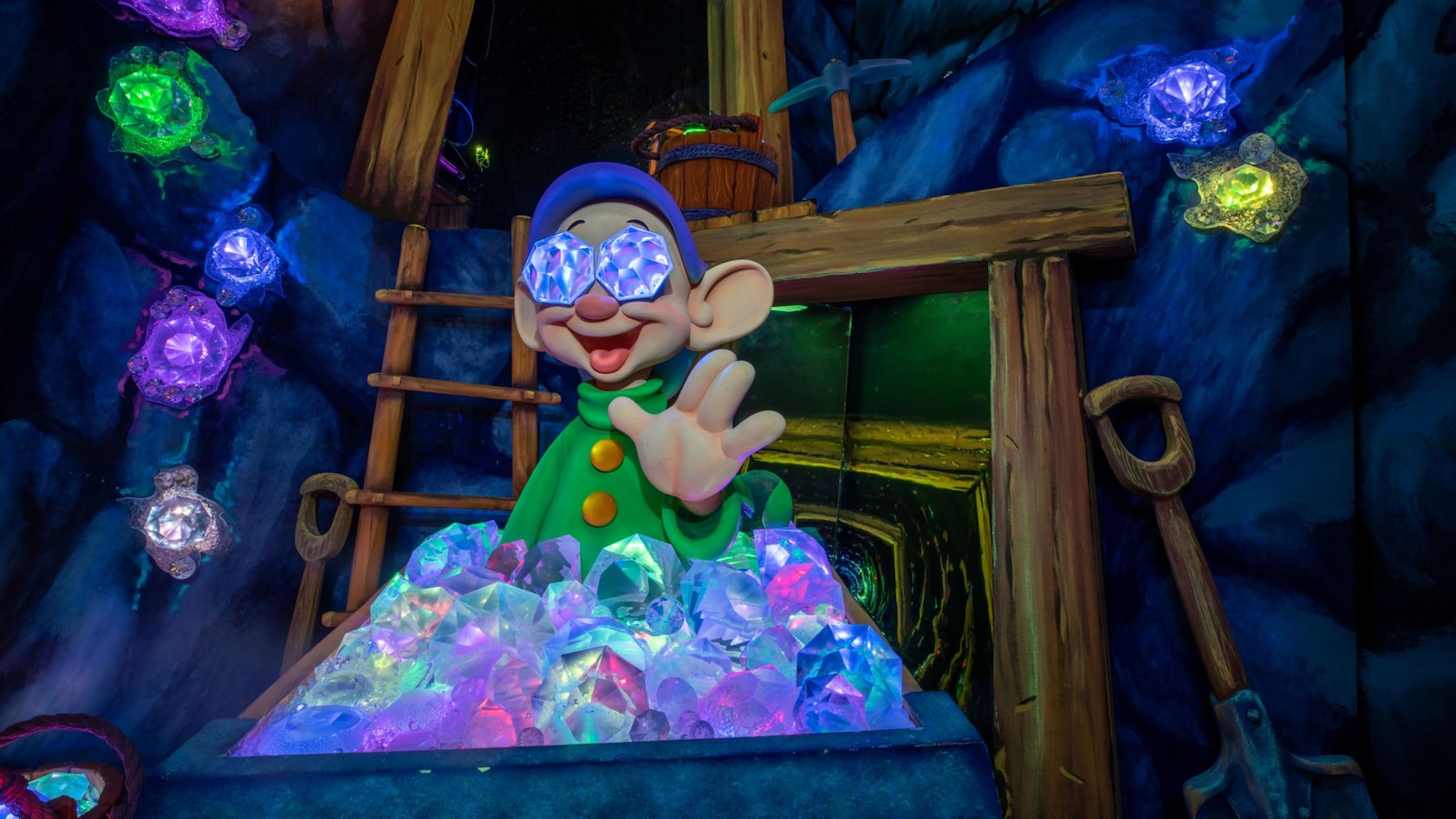 Dopey the Dwarf waves hello from behind a mining car filled with gems in the Snow White’s Enchanted Wish attraction at Disneyland Park in California