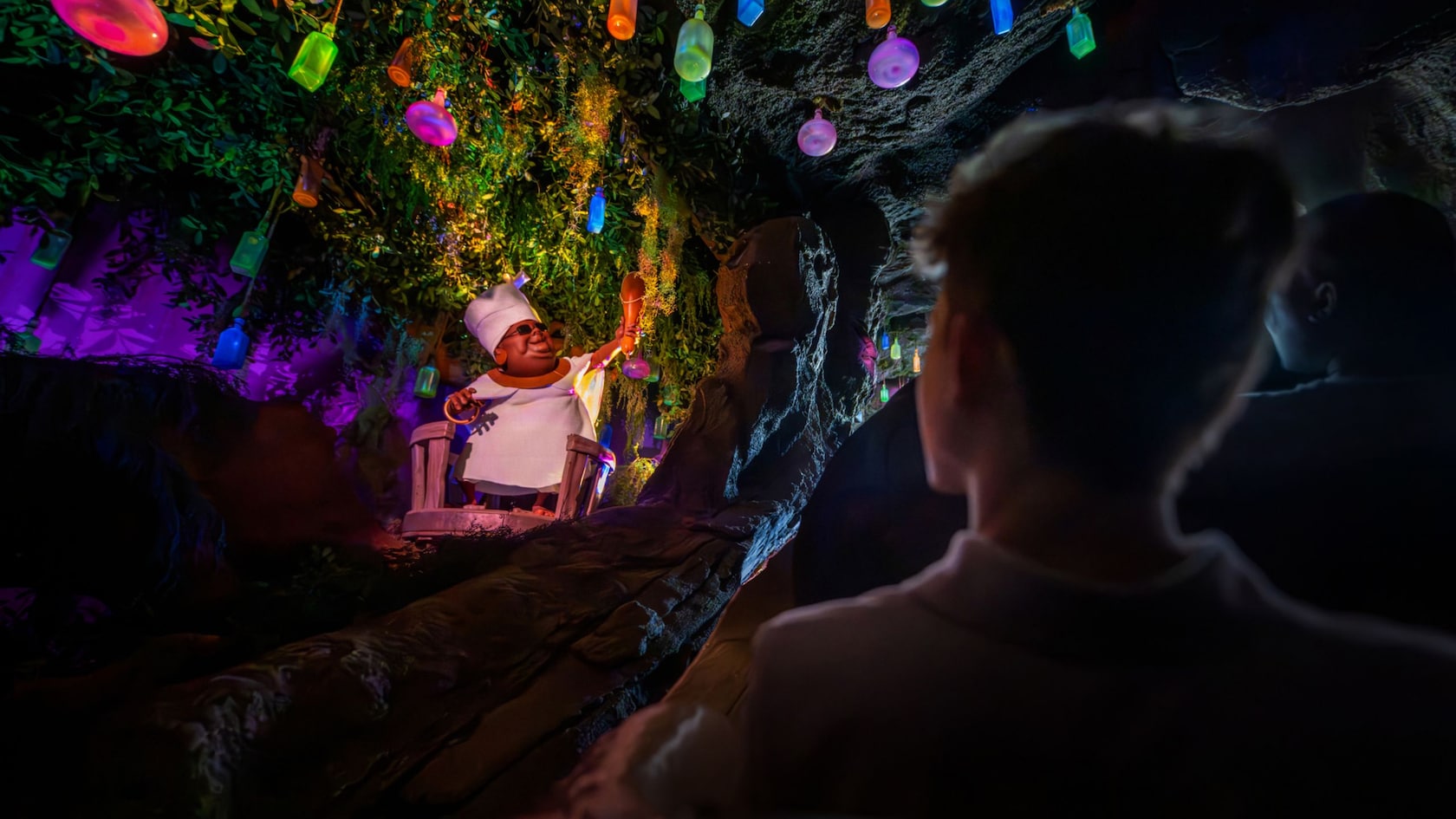 Un grupo de Visitantes pasan junto a Mama Odie en Tiana’s Bayou Adventure