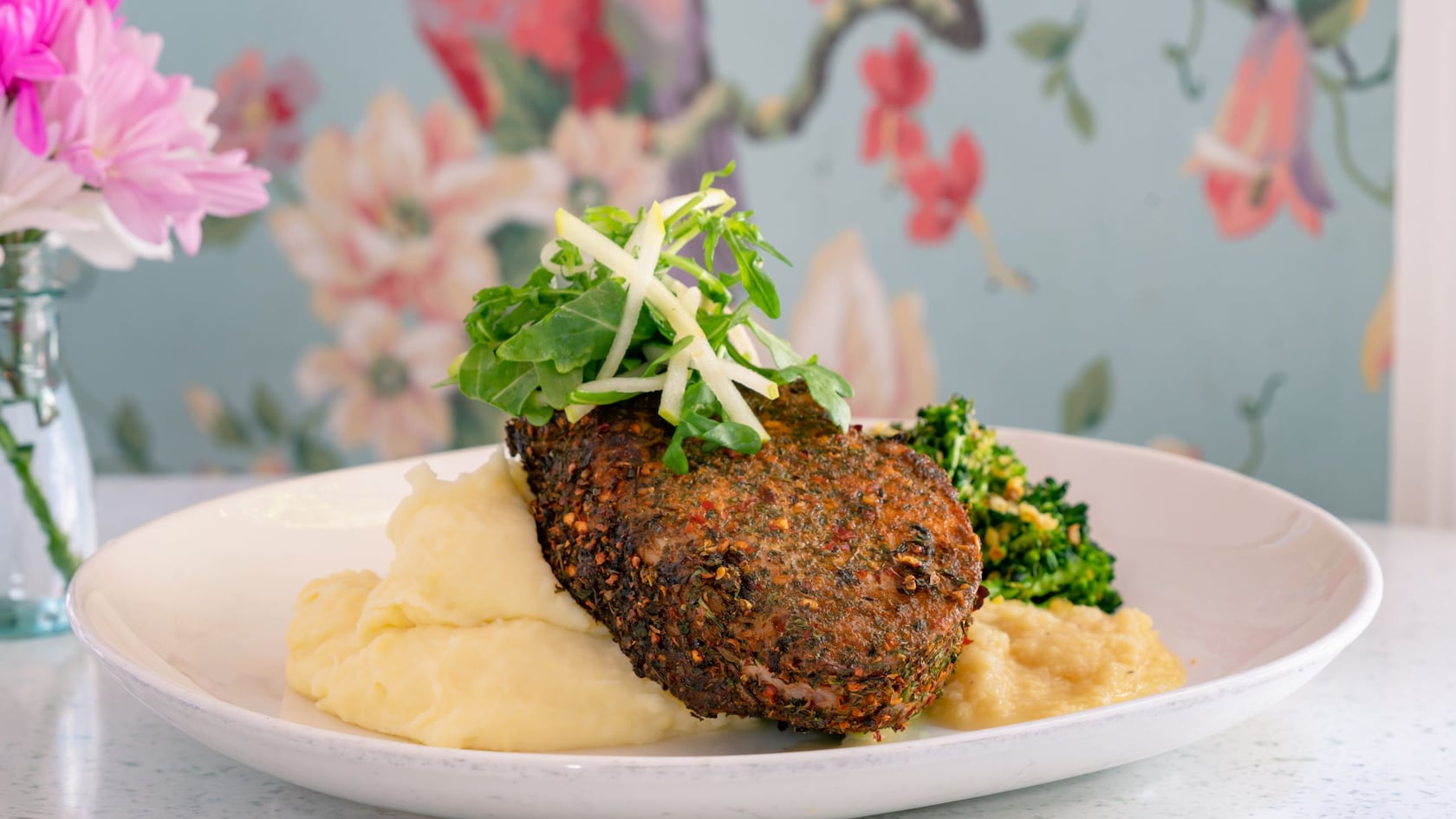Pork Chop served over mashed potatoes with greens from River Belle Terrace