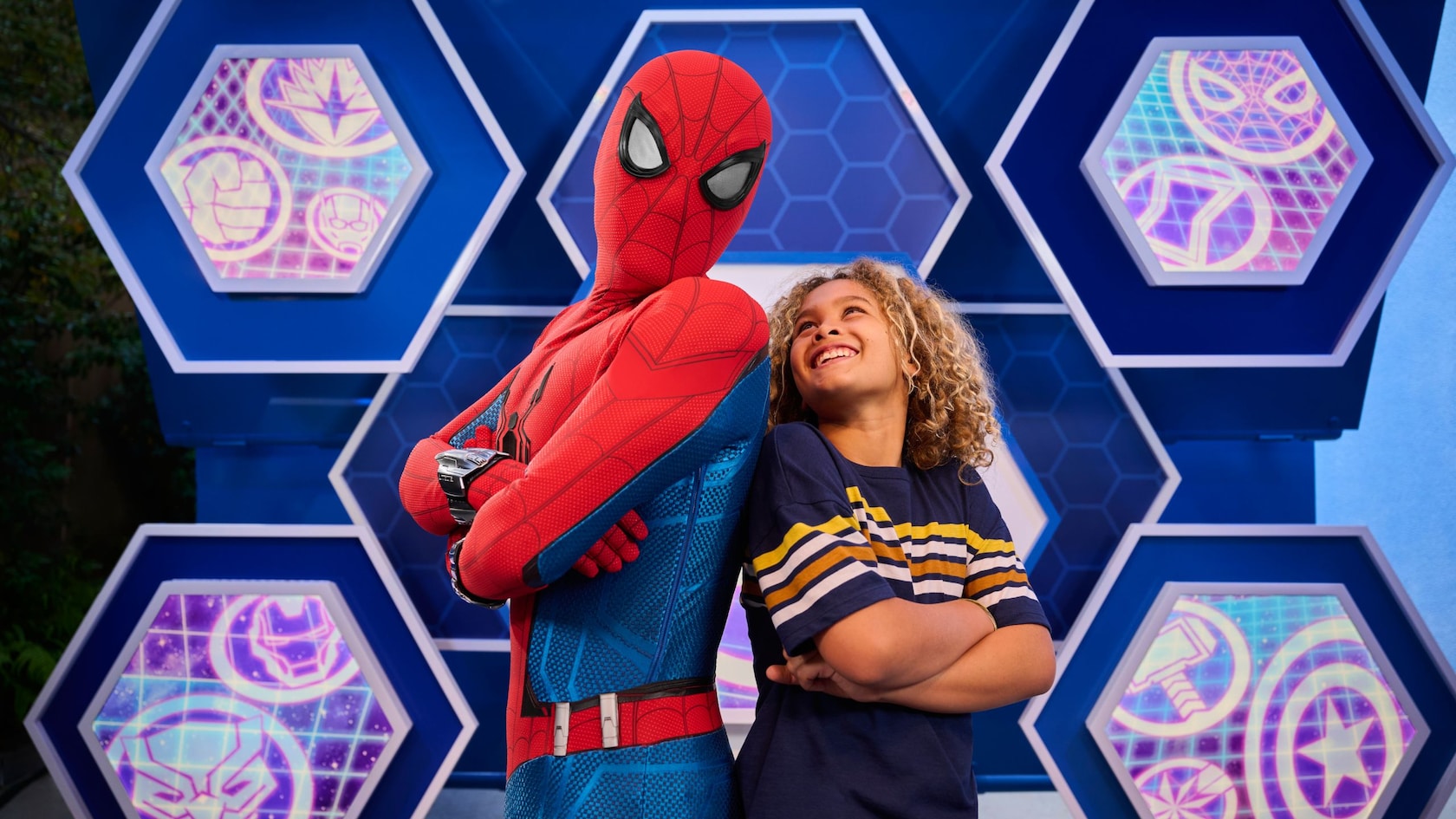 A young Guest posing for a picture with Spider Man in Disney California Adventure Park