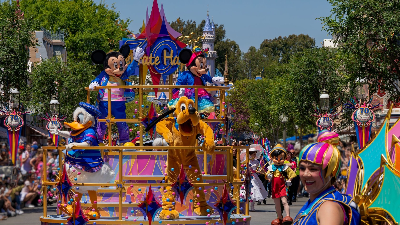 Mickey Mouse, Minnie Mouse, Donald Duck y Pluto en una carroza durante Celebrate Happy Cavalcade