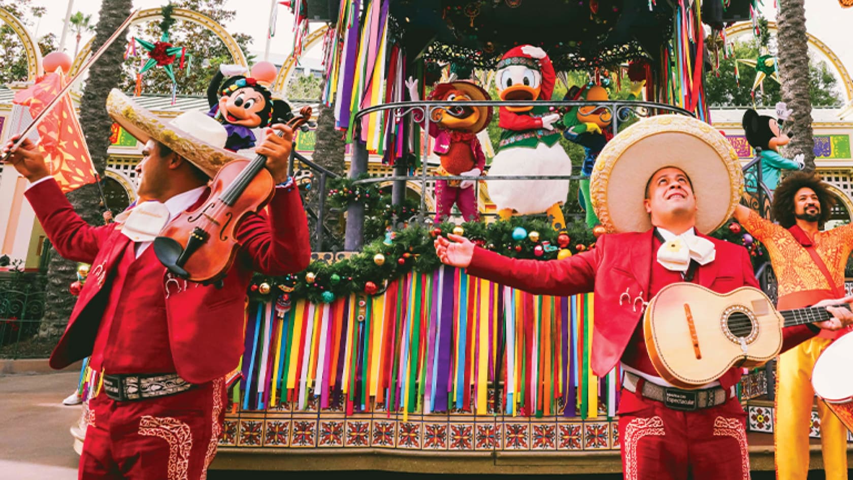 Mariachi musicians playing in front of a parade float carrying Minnie Mouse, Donald Duck and Mickey Mouse