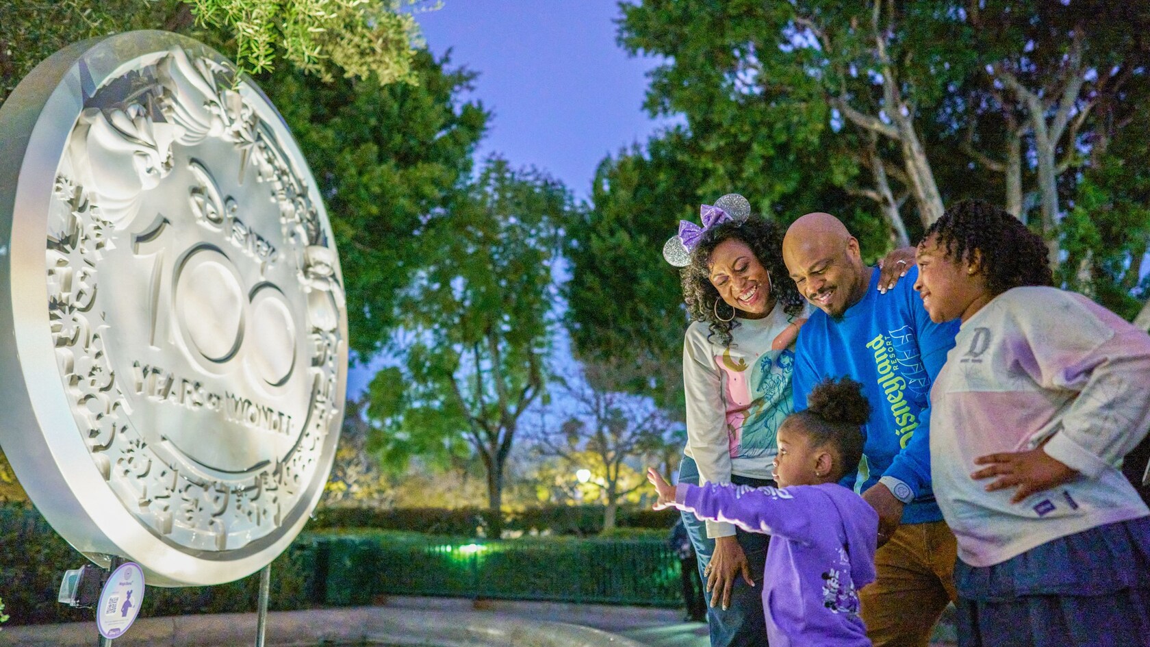 Una escultura de las hadas de Disney volando por encima de las palabras “Disney 100 Years of Wonder”