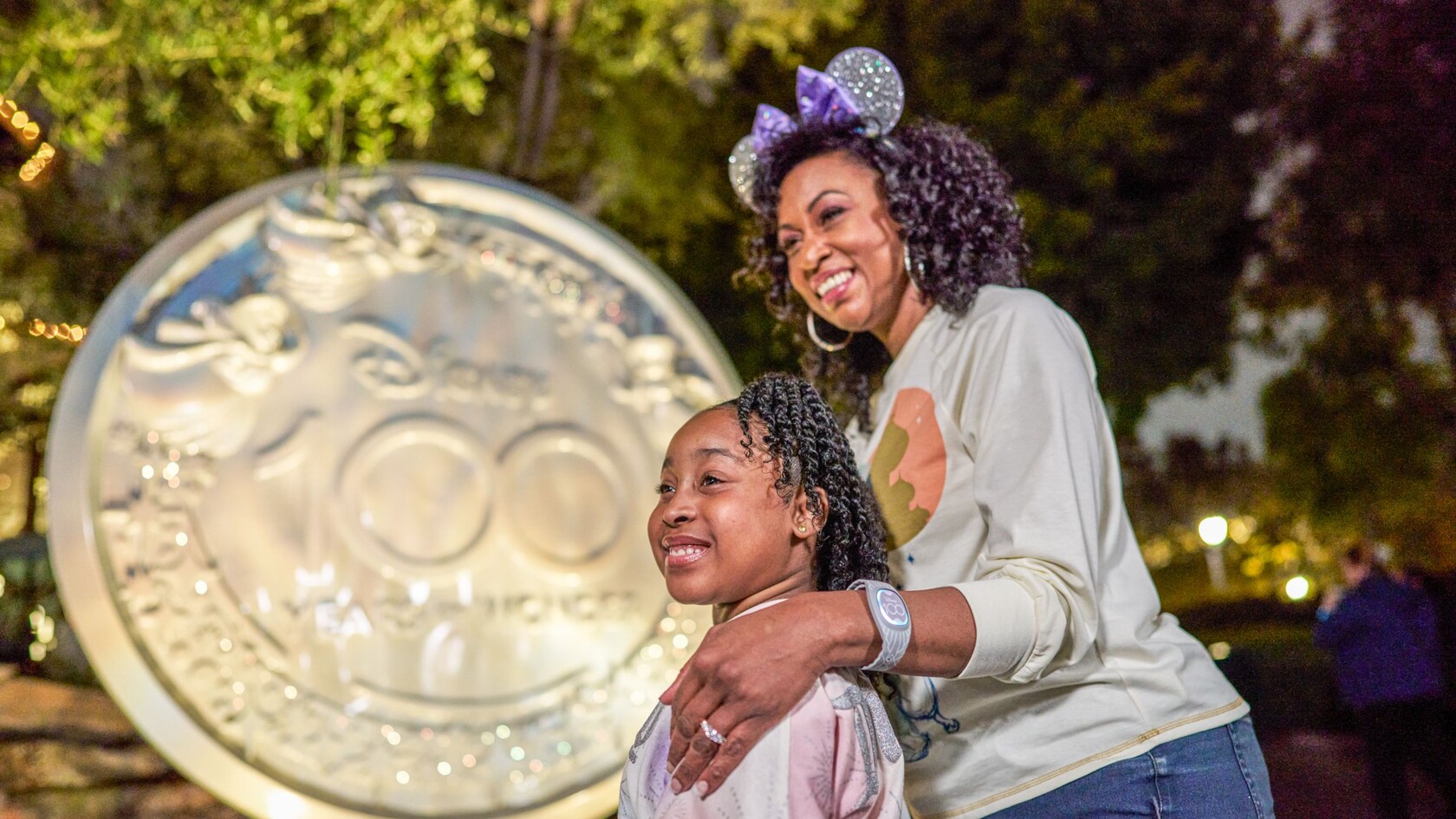 Una escultura de las hadas de Disney volando por encima de las palabras “Disney 100 Years of Wonder”