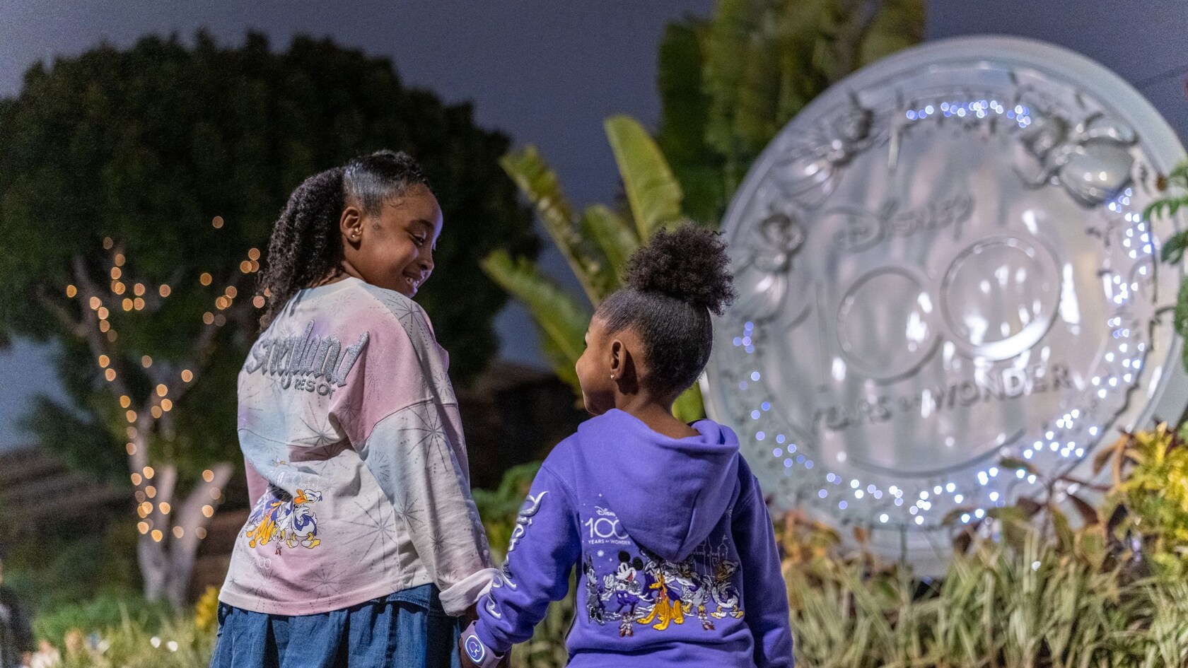 Una escultura de las hadas de Disney volando por encima de las palabras “Disney 100 Years of Wonder”