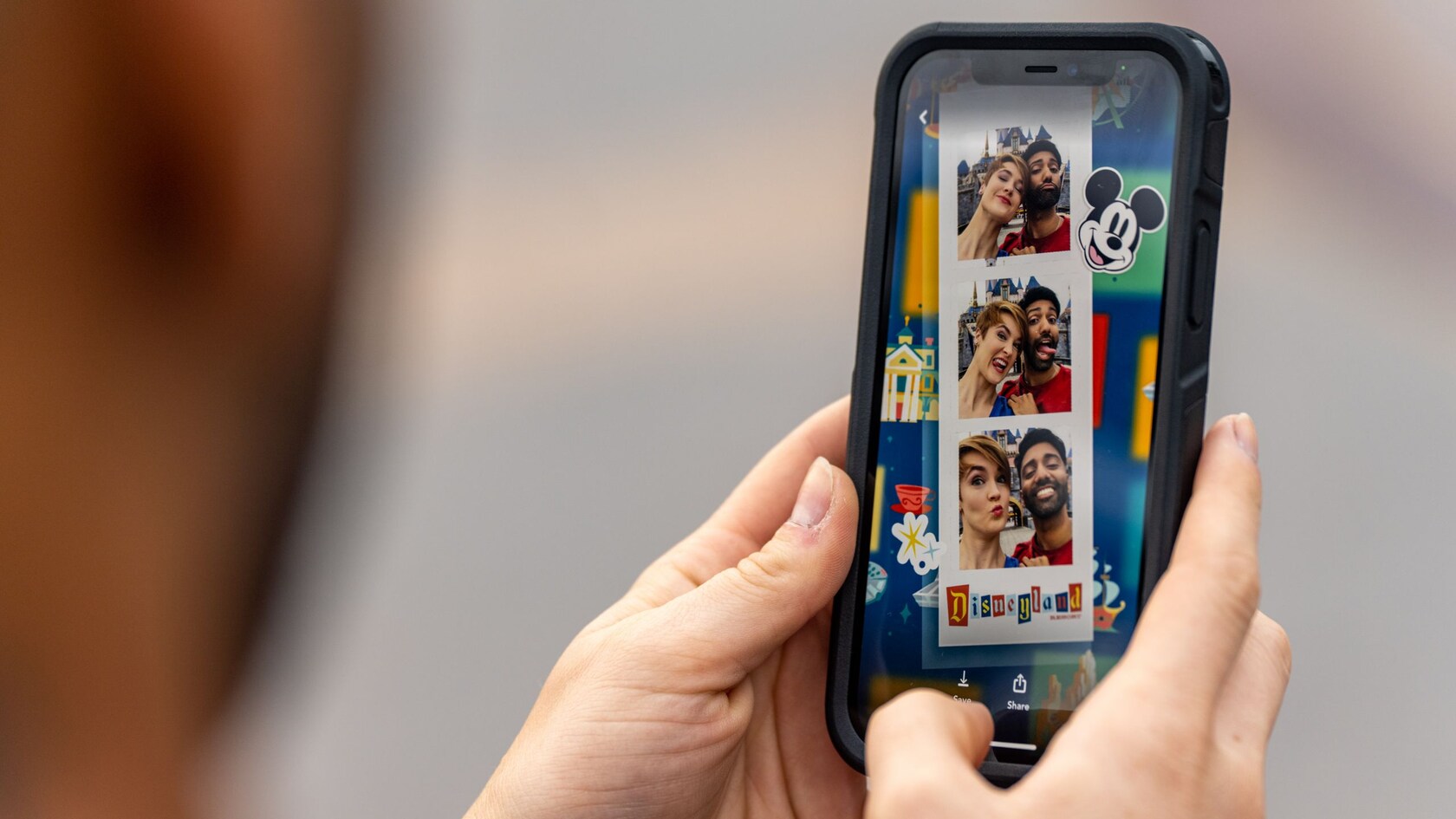 A mobile phone contains selfies of a couple arranged in a Disney themed photo strip, similar to pictures from a photo booth