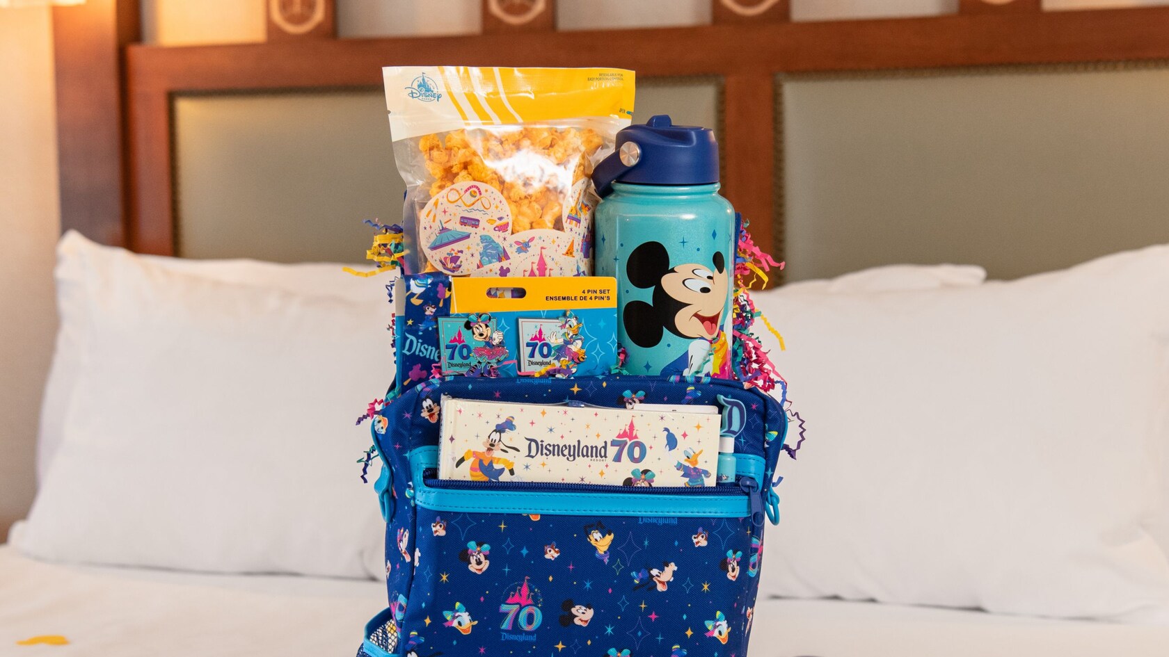 A Disneyland Resort 70th Celebration welcome basket on a Disneyland Resort hotel bed
