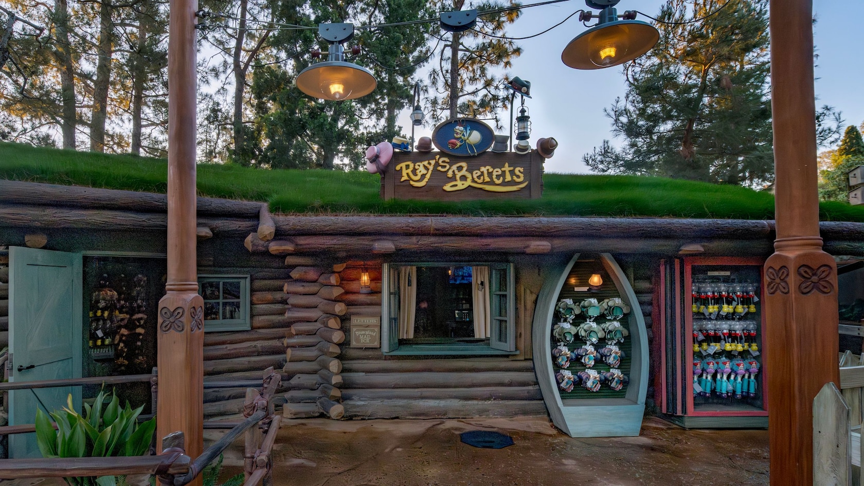 A cabin with grass on the roof, merchandise displayed out front and a sign that says ‘Ray’s Berets’