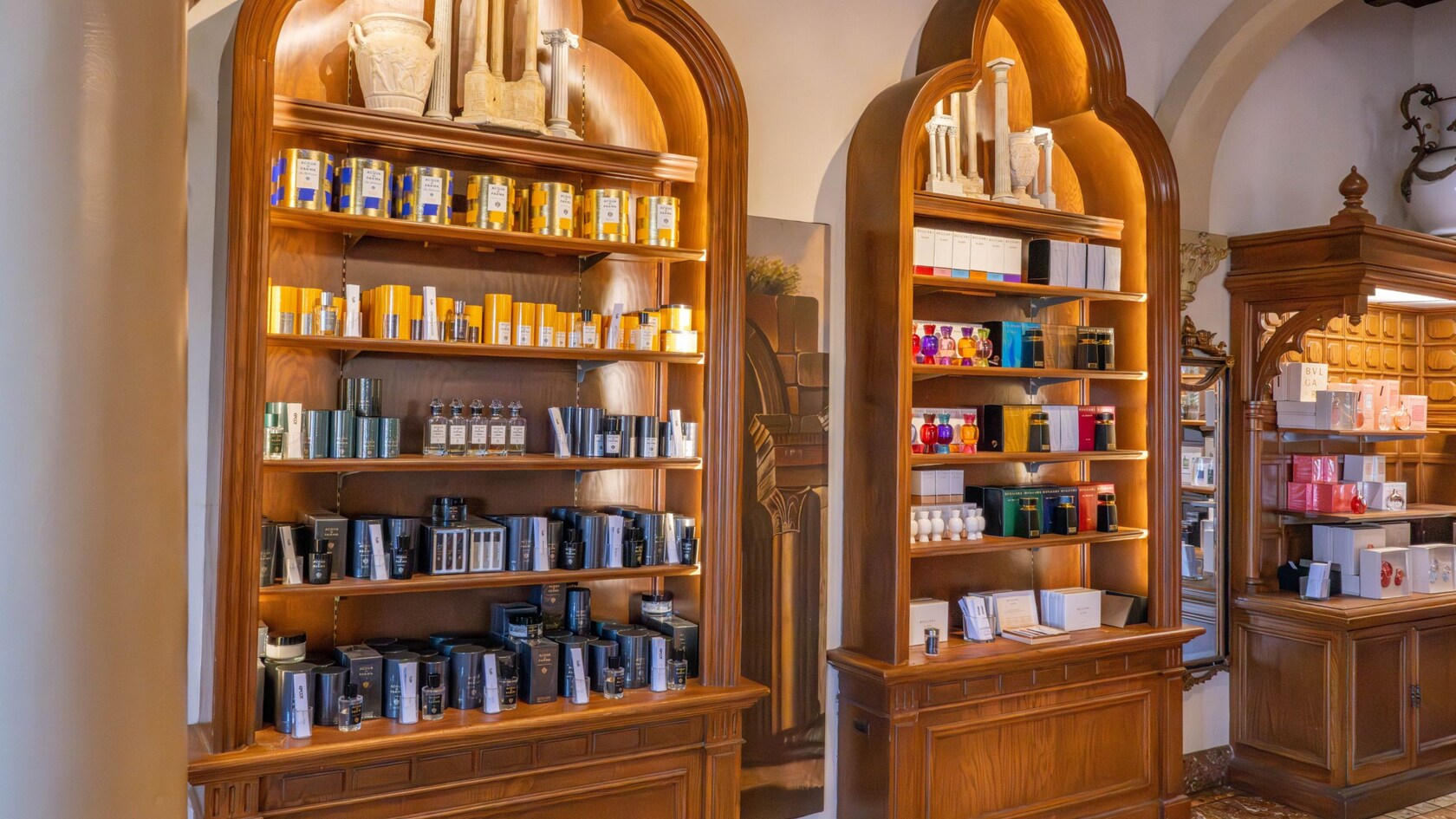 Three wooden display shelves holding fragrances and personal care items inside of Il Bel Cristallo at Epcot