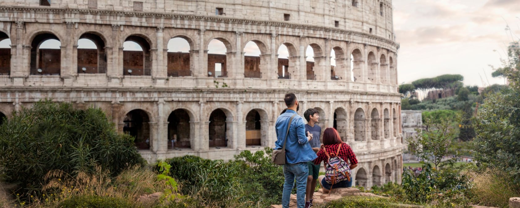 A couple and their child outside the world famous Colosseum in Rome, Italy