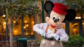 米奇老鼠（Mickey Mouse）站在招牌上写着“Buena Vista Street”（博伟街）的街车前面