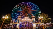 A flashy sign identifies Pixar Pal A Round, a towering ferris wheel with Victorian touches