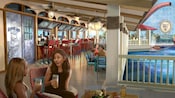 一对夫妇在天堂码头（Pixar Pier）附近，面对摆满食物和饮料的餐桌上对视微笑