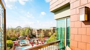 The view from a balcony at Disney’s Grand Californian Hotel and Spa, overlooking a pool and Disney California Adventure Park in the distance