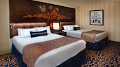 果物の木をテーマにした壁紙を備えたホテルの部屋にクイーンサイズのベッド2台