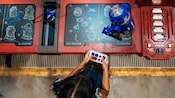 Using a remote control, a girl operates a droid she assembled at Droid Depot