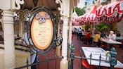 People in a restaurant seating area near a sign that reads Carnation Café