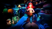 Ariel and flounder near a statue of Prince Eric
