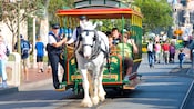 A horse pulls an open streetcar full of Guests down Main Street U.S.A.