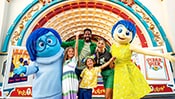 ディズニーとピクサーの映画『インサイド・ヘッド』のキャラクター、ヨロコビとカナシミと写真を撮る家族
