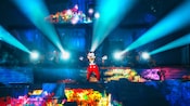 Lights project from Mickey’s fingertips as he performs onstage during the Fantasmic! nighttime spectacular