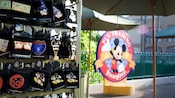 遮阳伞附近的装饰徽章以及写着“Pin Trading Disneyland Resort”（迪士尼乐园度假区徽章交换）的标志