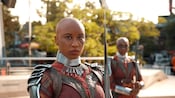 Two Dora Milaje warriors stand with large spears