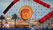 A large roller coaster track goes around a large sign that says Pixar Pier