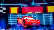Lightning McQueen, onstage in front of a large crowd, with his racing number featured above him