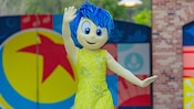 Pixar Plaza에서 뛰고 있는 Pixar 영화 인사이드 아웃의 조이 