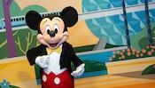 미키와 친구들 만나서 인사 나누기 장소 외부의 Epcot 벽화 앞에서 포즈를 취한 미키  
