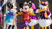 Mickey, Minnie, Donald and Daisy dance in their fancy celebration outfits