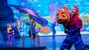 Performers with puppets depicting Marlin, Dory, Nemo and Mister Ray on a stage
