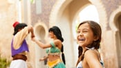 一个女孩在阿拉丁（Aladdin）和茉莉公主（Jasmine）翩翩起舞时开心地笑着