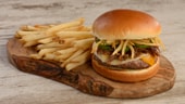 Showstopper Burger featuring a burger with cheese, jalapeños, crispy onions and fries on the side