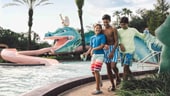 ディズニー・ポートオーリンズ・リゾート – フレンチ・クオーターにあるダブルーン・ラグーン・プールのそばを歩く若いゲスト 3 人