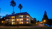 Disney's Port Orleans Resort – French Quarter의 3층짜리 숙박 시설이 밤에 불빛으로 반짝이는 모습 