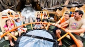 A family sits in a round raft, thrilled by the Kali River Rapids ride
