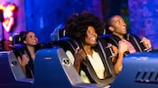 三个孩子坐在一辆加长型豪华轿车里，进行“史密斯飞船”摇滚飞车（Rock 'n' Roller Coaster Starring Aerosmith）的惊险之旅