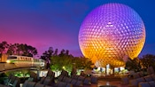 The Disney Monorail glides by the lighted Spaceship Earth