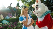 흰 토끼 옆에 서 있는 앨리스