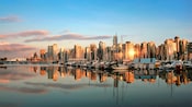 Un atardecer ilumina el puerto de Victoria, Canadá, con la ciudad detrás Un atardecer ilumina el puerto de Victoria, Canadá, con la ciudad detrás
